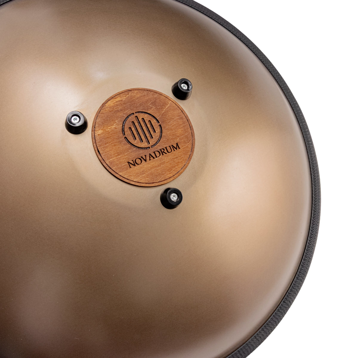 Close-up back view of Novadrum 48 big steel tongue drum in stainless steel, focusing on the wooden cover with engraved ‘NovaDrum’ branding, rubber feet, and black rope rim.