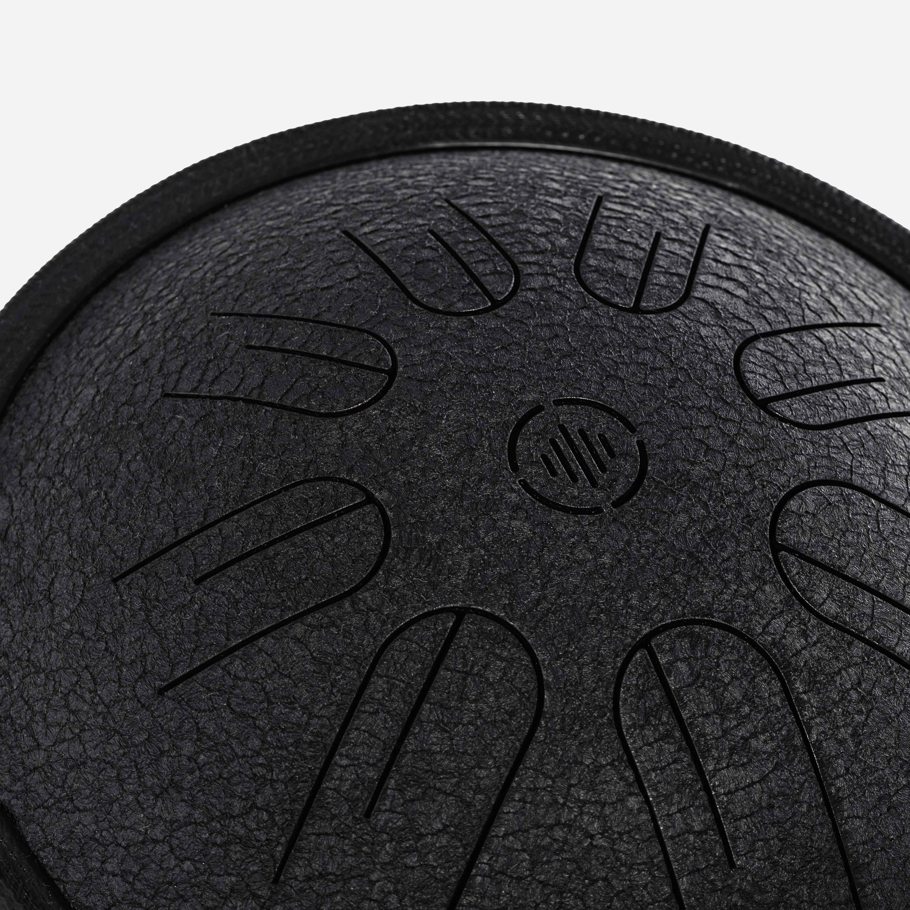 Close-up front view of Novadrum 28 steel tongue drum in black textured finish, featuring precision-cut tongues symmetrically arranged around a central logo