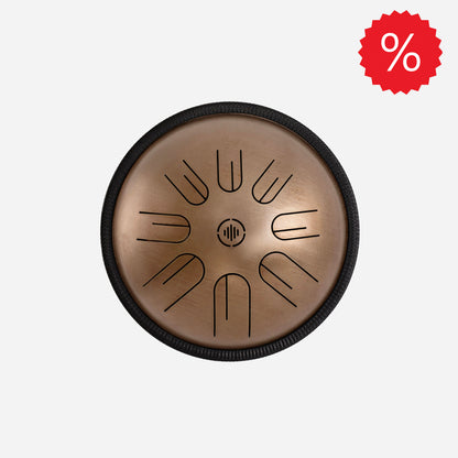 Front view of Novadrum 28 steel tongue drum in stainless steel, with precision-cut tongues arranged symmetrically around a central logo, with discount icon