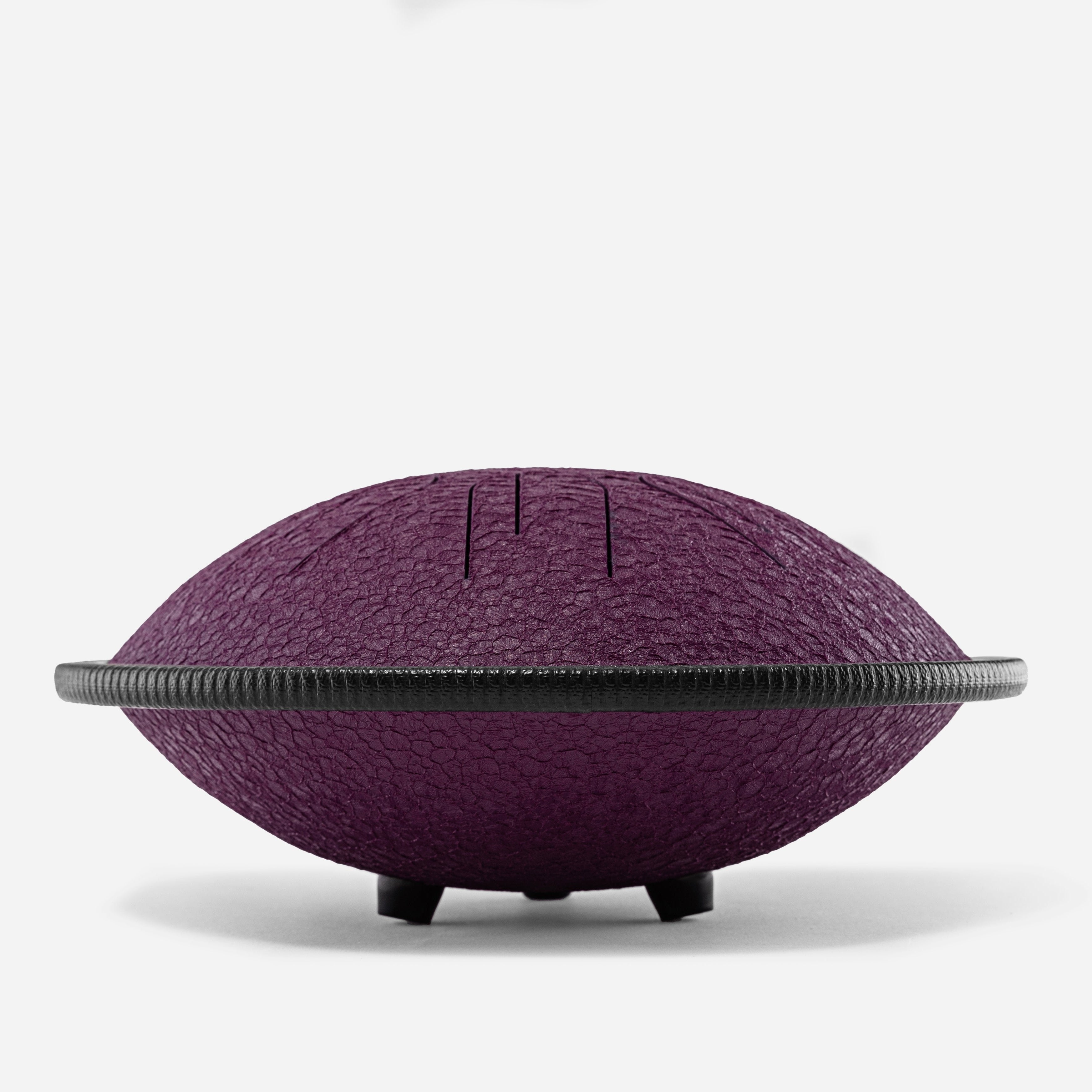 Side view of Novadrum 28 steel tongue drum in purple textured finish, featuring a black protective rim and three rubber feet for stability.