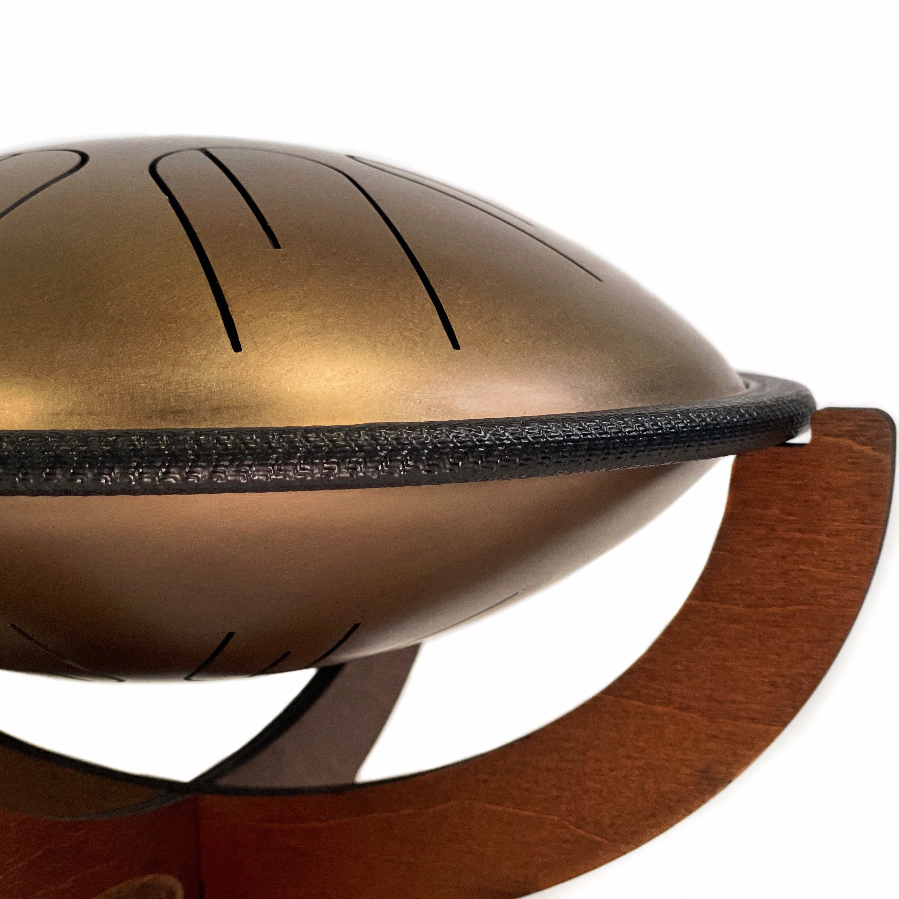 Close up side view of Novadrum 28 two-sided steel tongue drum on wooden stand, featuring a black protective rim and three rubber feet for stability.