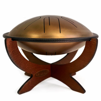 Side view of Novadrum 28 two-sided steel tongue drum on wooden stand, featuring a black protective rim and three rubber feet for stability.