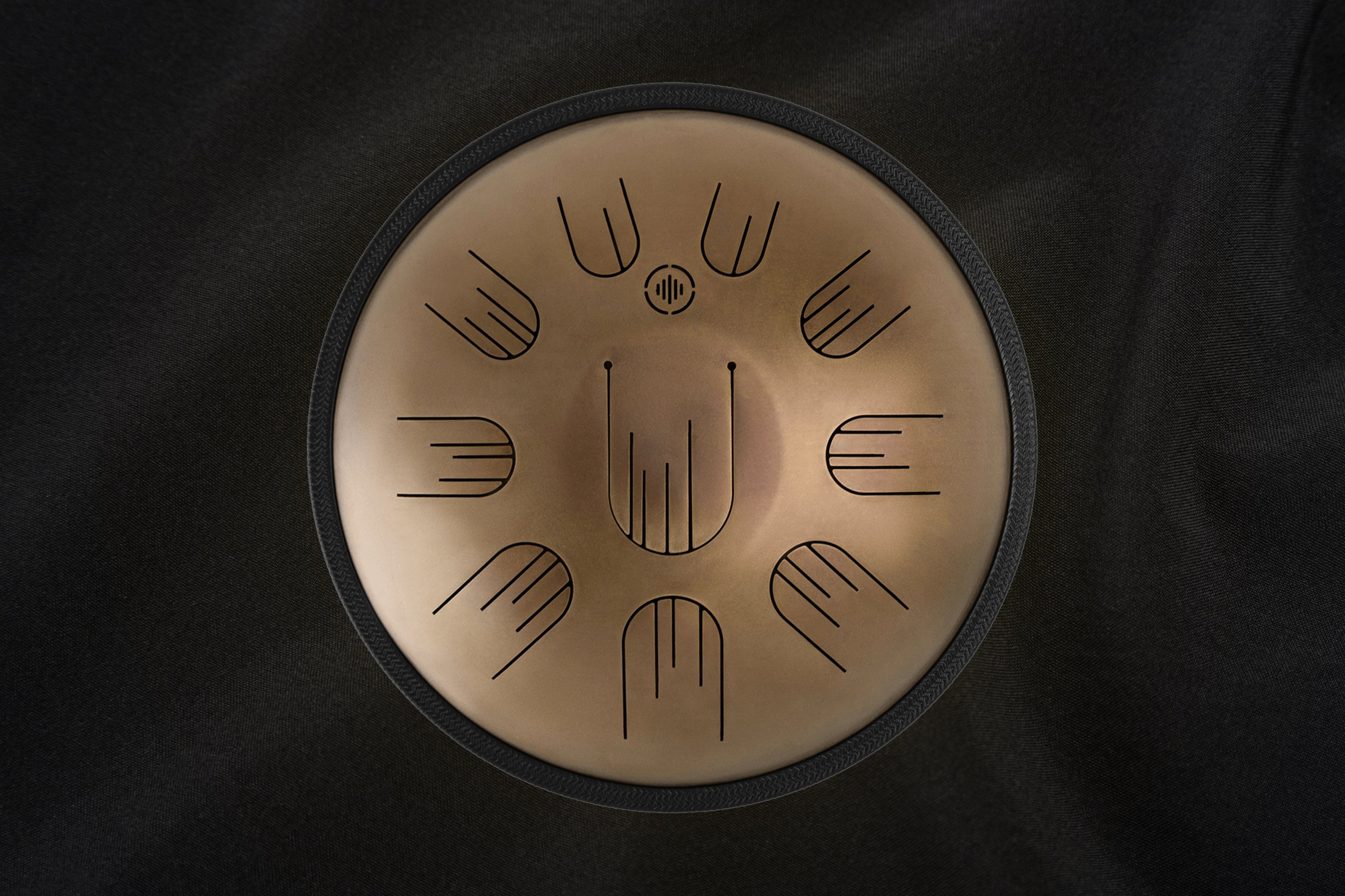 Front view of Novadrum 38 steel tongue drum in stainless steel, with precision-cut tongues arranged symmetrically around a central logo