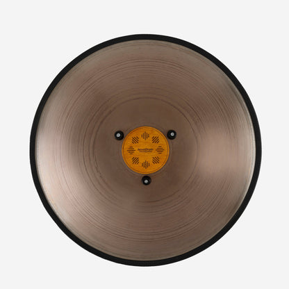 Back view of Novadrum 48 big steel tongue drum in stainless steel, showing a wooden cover with engraved ‘NovaDrum’ branding, rubber feet, and black rope rim.