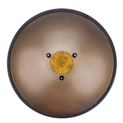 Back view of Novadrum 48 big steel tongue drum in stainless steel, showing a wooden cover with engraved ‘NovaDrum’ branding, rubber feet, and black rope rim.