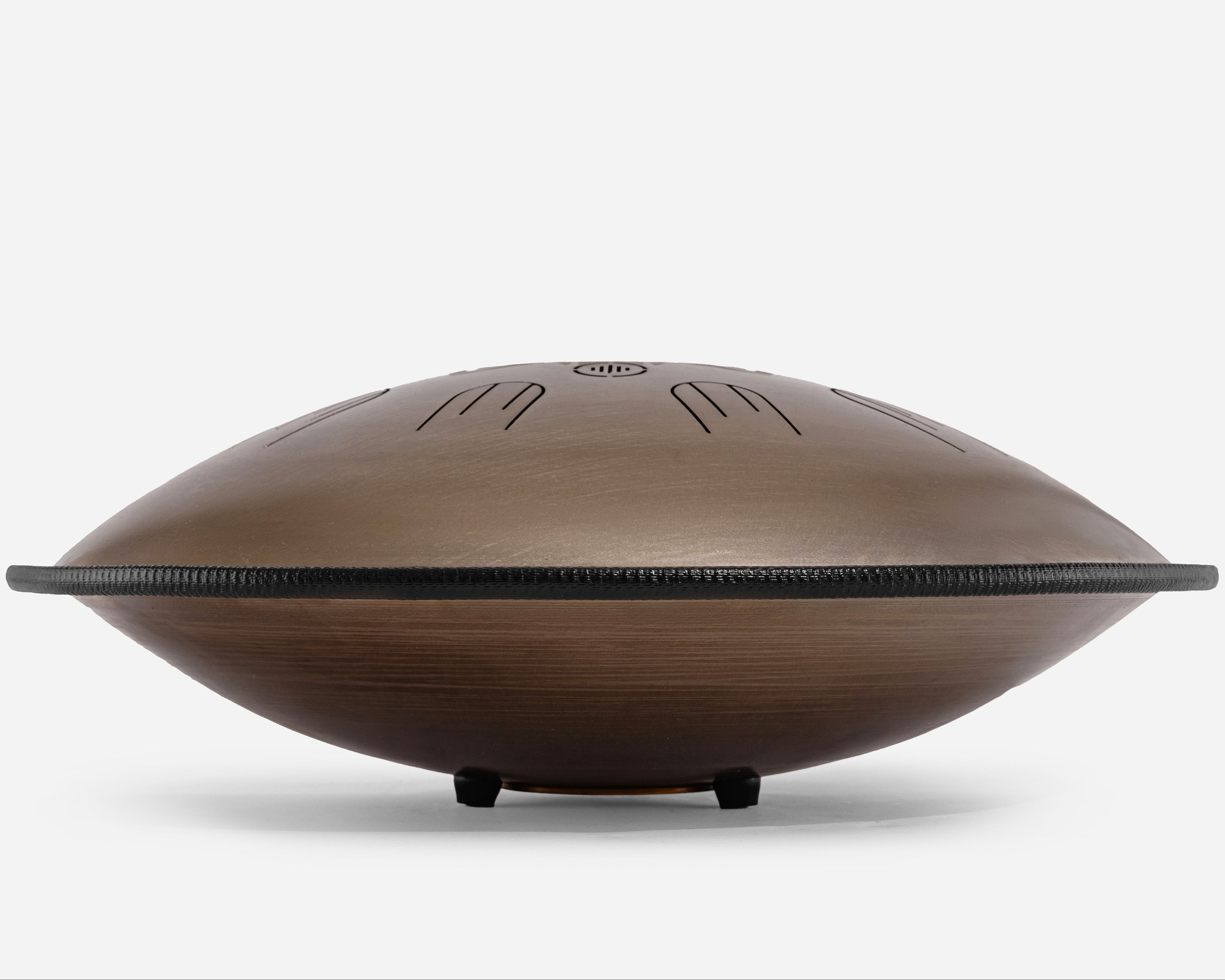 Side view of Novadrum 48 big steel tongue drum in stainless steel, featuring a black protective rim and three rubber feet for stability.
